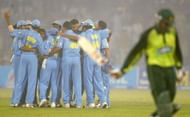 LAHORE, PAKISTAN - MARCH 24 : The Indian team (L) celebrate as Shoaib Malik (R) of Pakistan walks back to the pavillion after being dismissed during the fifth Pakistan v India one-day international match played at the Gadaffi Stadium on March 24, 2004 in Lahore, Pakistan. India won the match by 40 runs to win the series 3-2. (Photo by Scott Barbour/Getty Images)   *** Local Caption ***